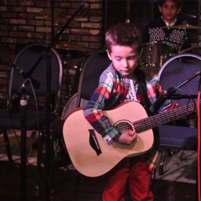 Young Boy Performing guitar on Stage